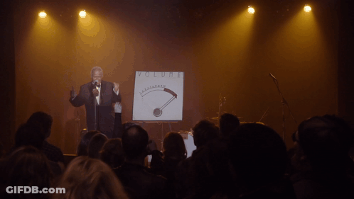 Man Singing Into Microphone At Volume Sign GIF