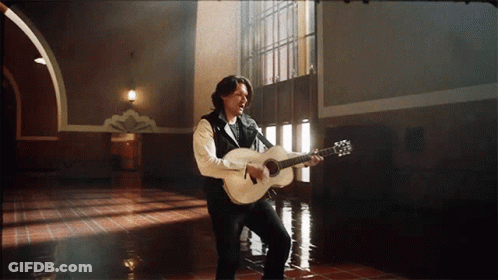 Man Singing Into Microphone Holding Guitar GIF