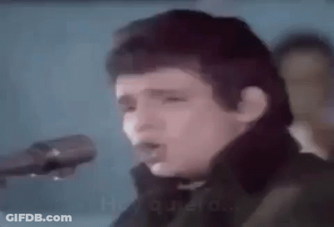 Man Singing Into Microphone Holding Guitar GIF