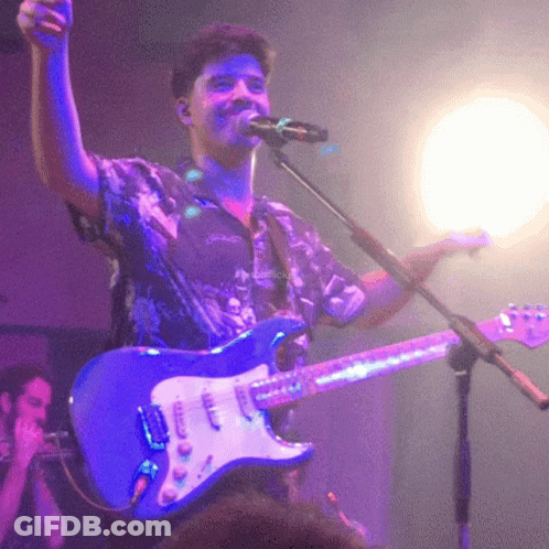 Man Singing Into Microphone Holding Guitar GIF