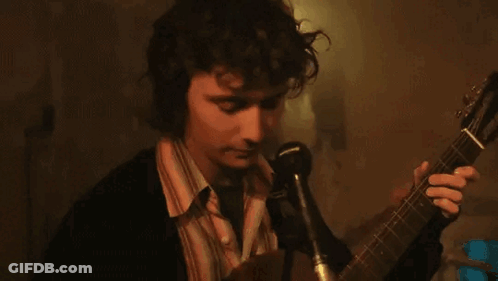 Man Singing Into Microphone Holding Guitar GIF