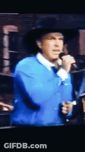 Man Singing Into Microphone In Blue Jacket GIF