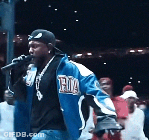 Man Singing Into Microphone In Blue Ria Jacket GIF