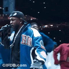 Man Singing Into Microphone In Blue Ria Jacket GIF