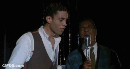Man Singing Into Microphone In Dark Room GIF
