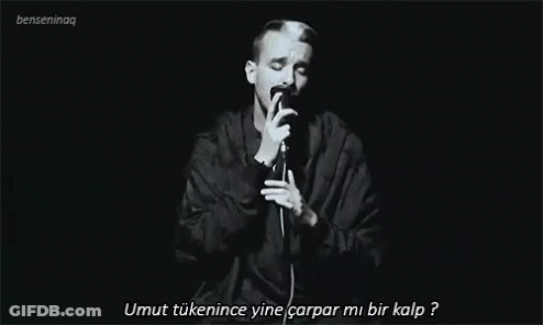 Man Singing Into Microphone In Dark GIF