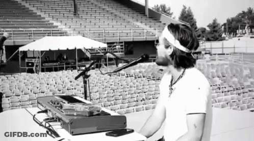 Man Singing Into Microphone In Empty Bleachers GIF