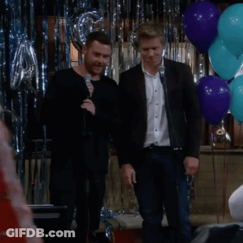 Man Singing Into Microphone In Front Of Balloons GIF