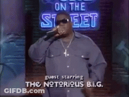 Man Singing Into Microphone In Front Of On The Street Sign GIF