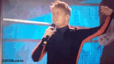 Man Singing Into Microphone In Front Of Window GIF