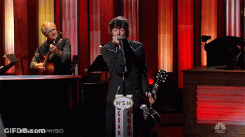 Man Singing Into Microphone Next To WSM Gran Sign GIF
