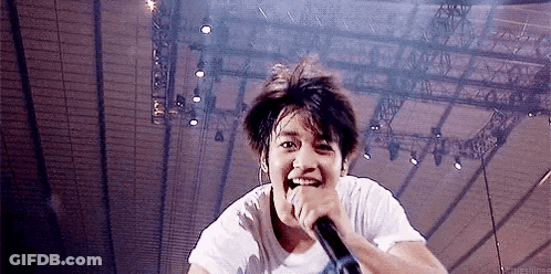 Man Singing Into Microphone On Stage GIF