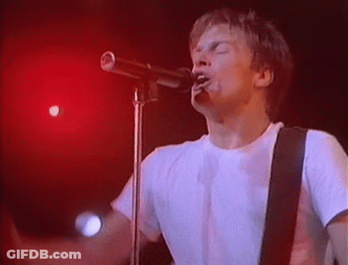 Man Singing Into Microphone On Stage GIF