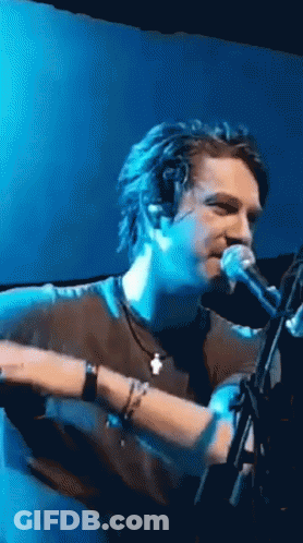 Man Singing Into Microphone On Stage GIF