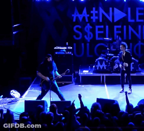 Man Singing Into Microphone On Stage With Selfie Sign GIF