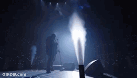 Man Singing Into Microphone On Stage With Smoke GIF