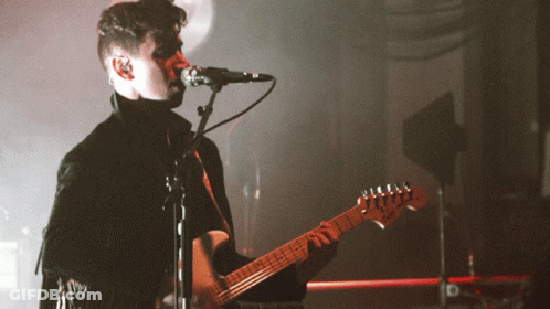 Man Singing Into Microphone Playing Guitar GIF