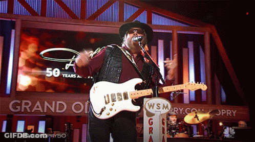 Man Singing Into Microphone Playing Guitar At Grand Ole Opry GIF