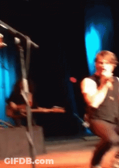 Man Singing Into Microphone Playing Guitar GIF