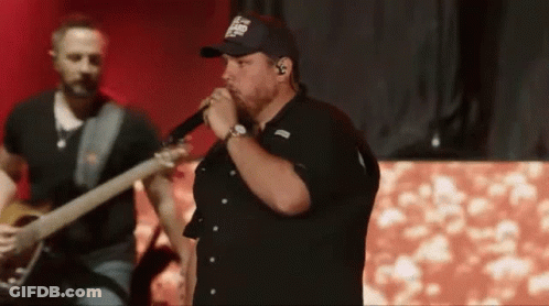 Man Singing Into Microphone Playing Guitar On Stage GIF
