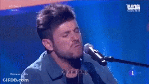 Man Singing Into Microphone Playing Piano Blue Background Traicion GIF