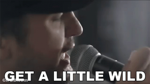 Man Singing Into Microphone Saying Get A Little Wild GIF