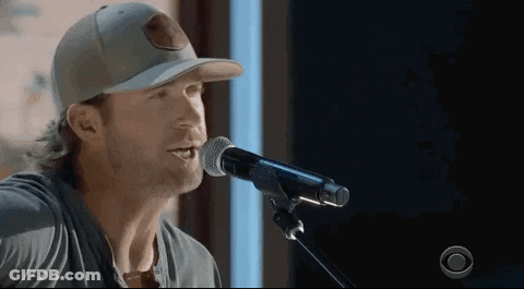 Man Singing Into Microphone Wearing Baseball Cap GIF