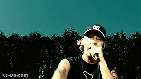 Man Singing Into Microphone Wearing Hat With Letter E GIF