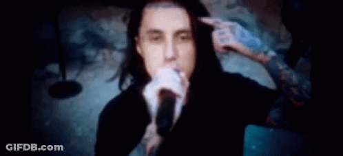 Man Singing Into Microphone While Another Holds His Hair GIF
