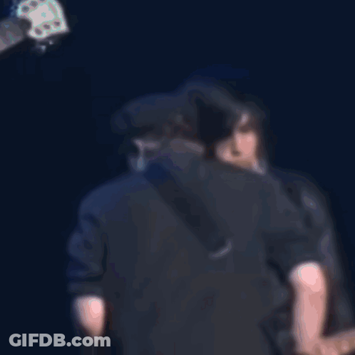 Man Singing Into Microphone While Another Kisses His Cheek GIF