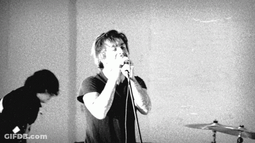 Man Singing Into Microphone While Another Watches GIF
