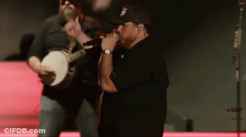 Man Singing Into Microphone While Banjo Player Plays GIF