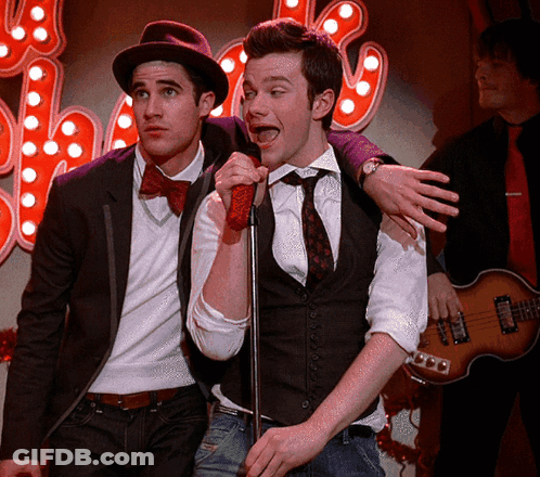 Man Singing Into Microphone With Another Behind GIF