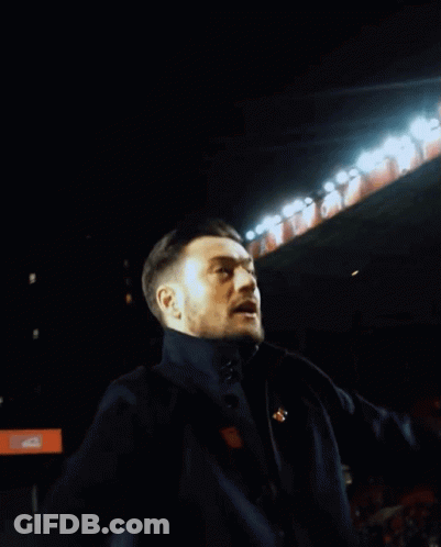 Man Singing Into Microphone With Arms Up GIF