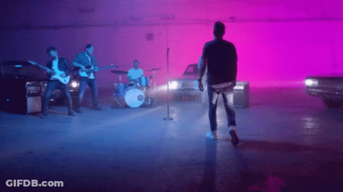 Man Singing Into Microphone With Band GIF