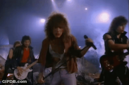 Man Singing Into Microphone With Band Playing Guitars GIF