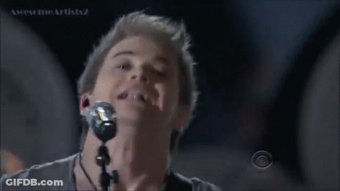 Man Singing Into Microphone With CBS Logo GIF