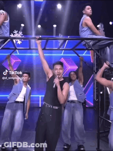 Man Singing Into Microphone With Dancing Men GIF