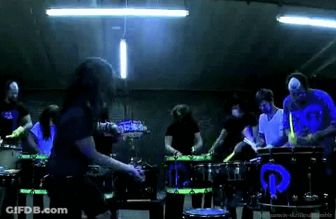 Man Singing Into Microphone With Drummers GIF