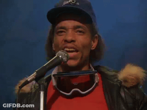 Man Singing Into Microphone With Goggles And Hat GIF