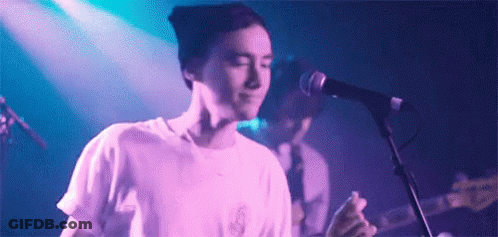 Man Singing Into Microphone With Guitar GIF