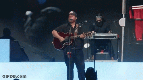 Man Singing Into Microphone With Guitar GIF
