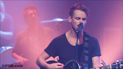 Man Singing Into Microphone With Guitar GIF