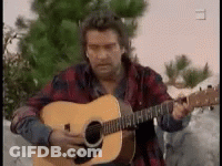Man Singing Into Microphone With Guitarist And Drummer GIF