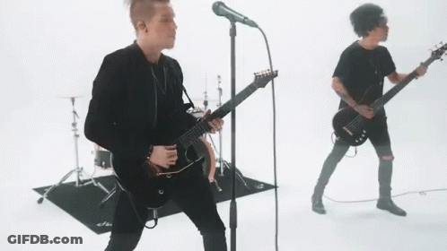 Man Singing Into Microphone With Guitarist And Drums GIF