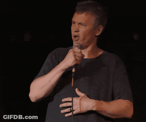 Man Singing Into Microphone With Hand On Stomach GIF