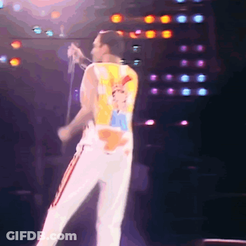 Man Singing Into Microphone With Queen Shirt GIF