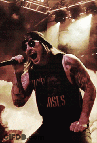 Man Singing Into Microphone With Roses Shirt GIF