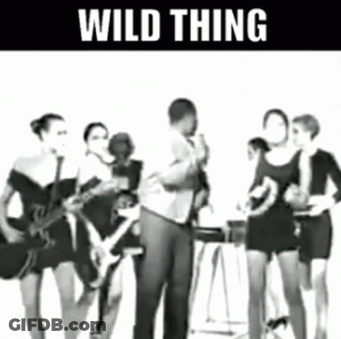 Man Singing Into Microphone With Women Playing Guitars GIF