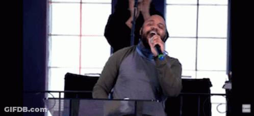 Man Singing Into Microphone Woman Behind Him GIF